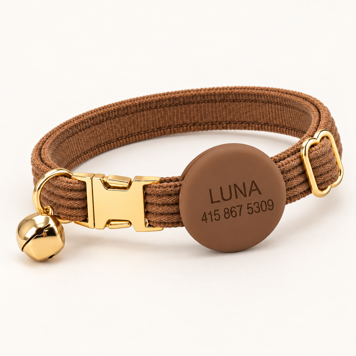 Cocoa | Corduroy cat collar with matching silicone AirTag holder, gold non-breakaway buckle and removable bell, soft natural studio hero.