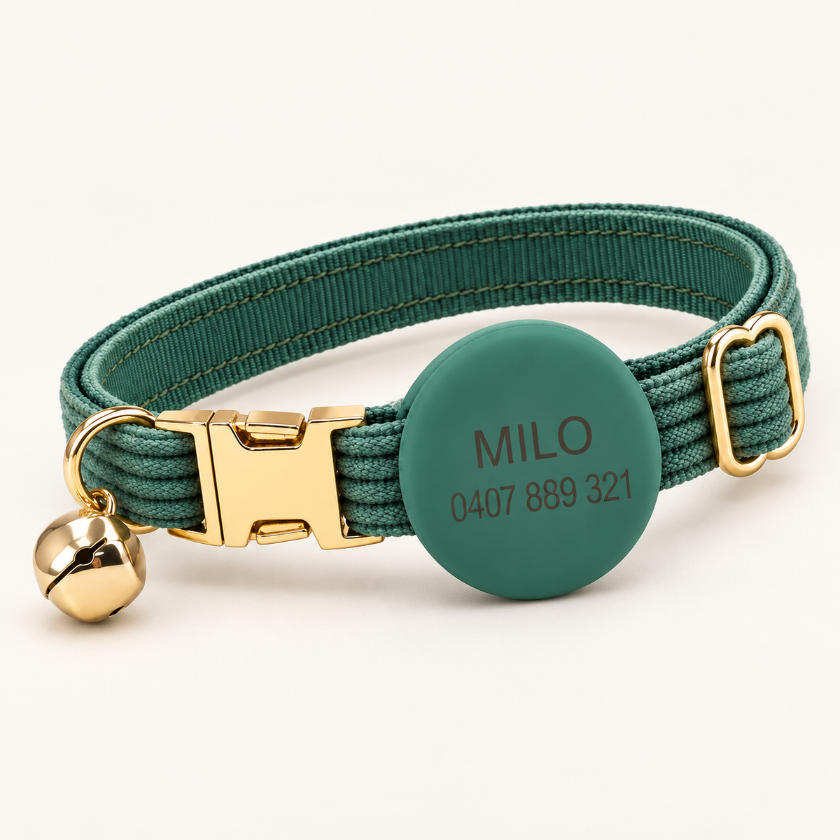 Juniper | Corduroy cat collar with matching silicone AirTag holder, gold non-breakaway buckle and removable bell, soft natural studio hero.